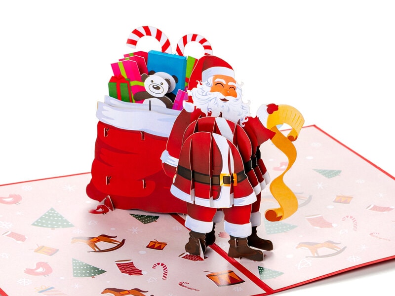 Pop up julkort med tomte som läser en önskelista. Välfylld julsäck bakom tomten. Kortet hittar du hos Coolstuff.